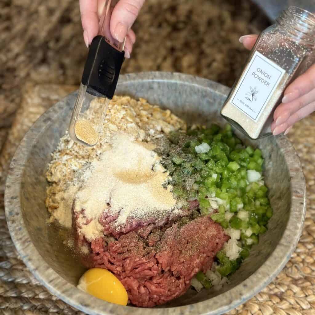 Adding ingredients to a bowl to make Salisbury steak.