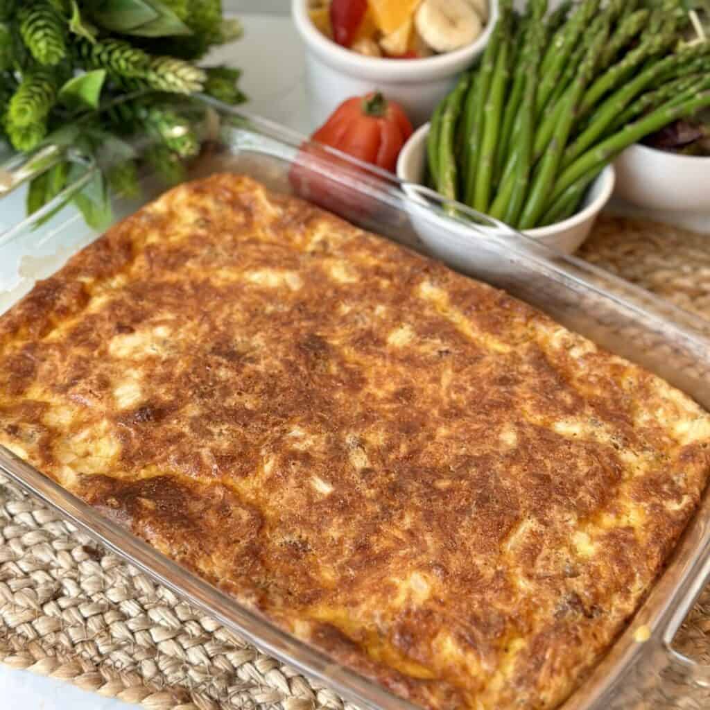 A breakfast casserole with asparagus on the side.