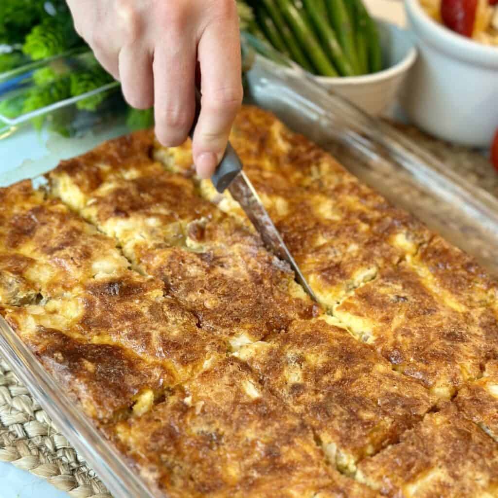 A breakfast casserole being sliced.