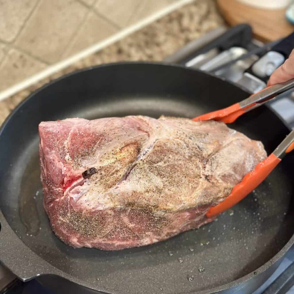 Searing a pork shoulder.