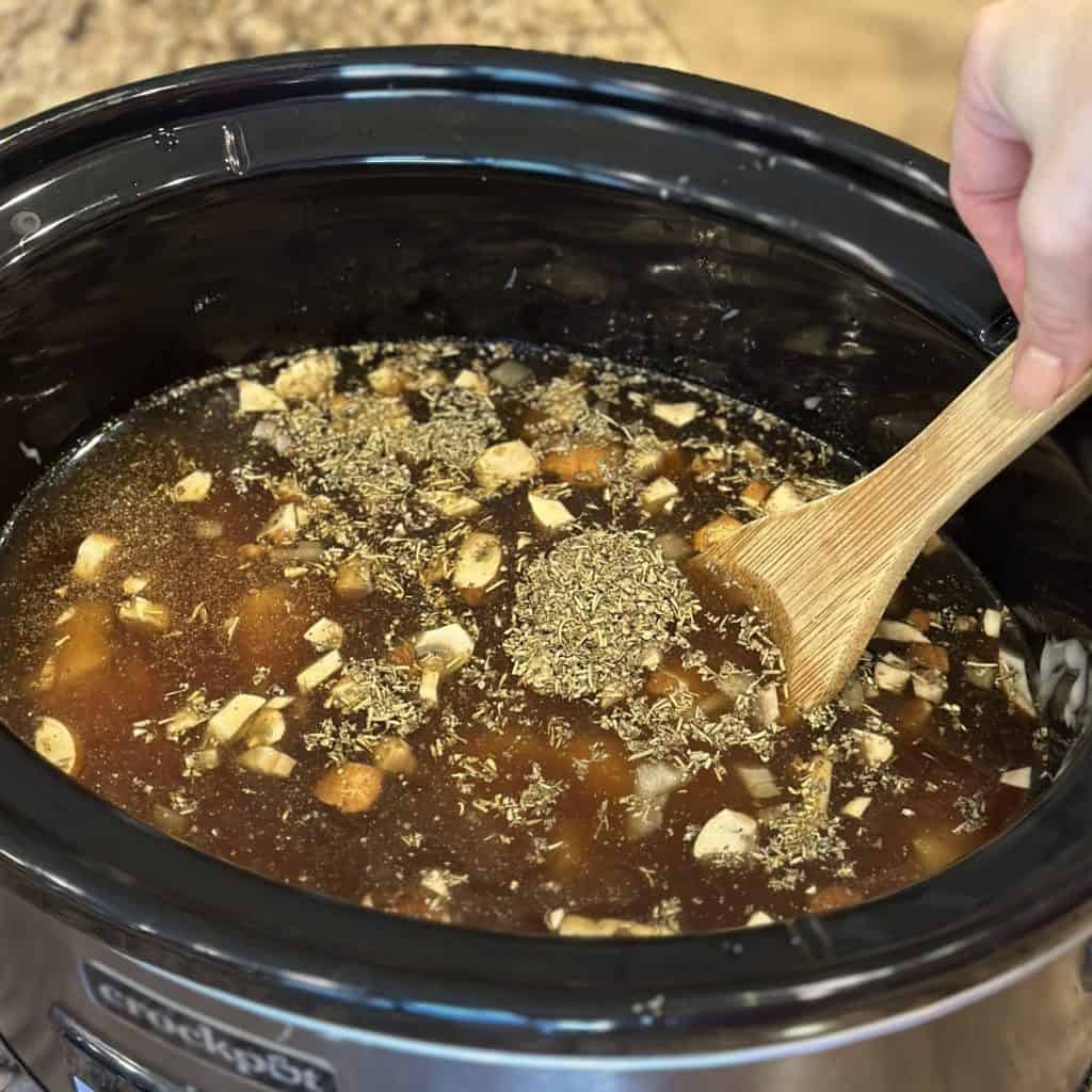 Stirring ingredients in a crockpot.