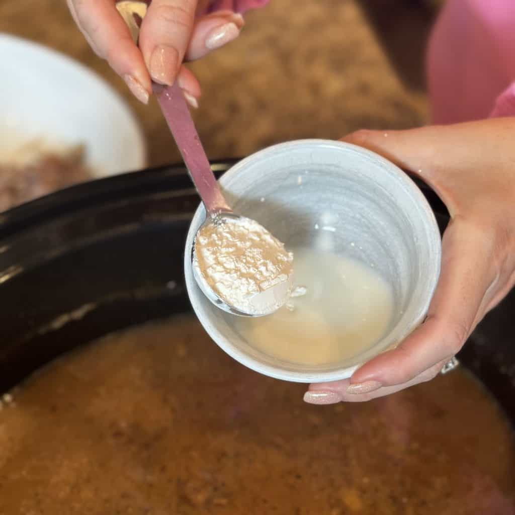 Mixing together cornstarch and milk in a small bowl.