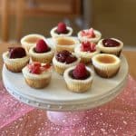 This is a picture of a plate of mini cheesecakes.