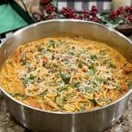 This is a picture of a pan of bolognese pasta with basil on top.