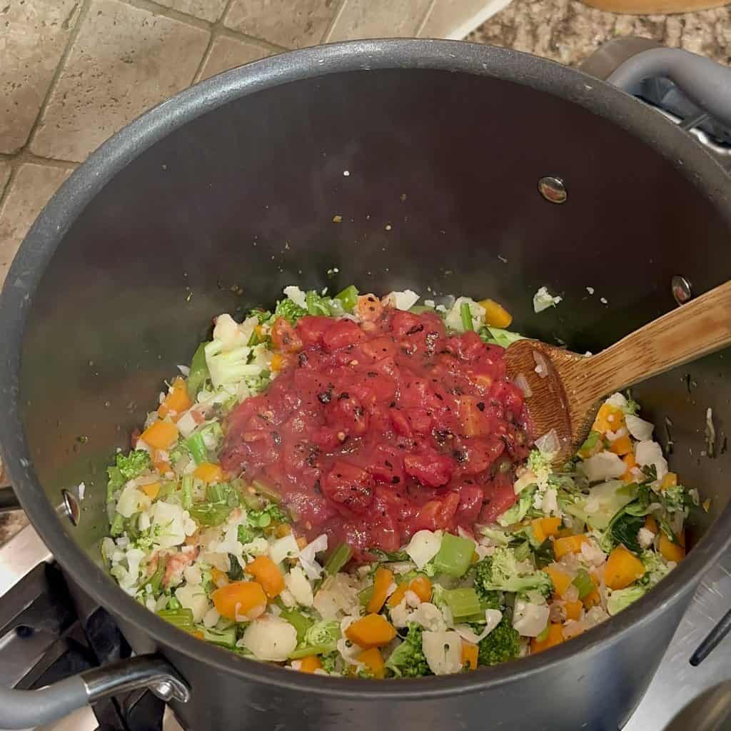 vegetables added to boiling broth in a soup pot