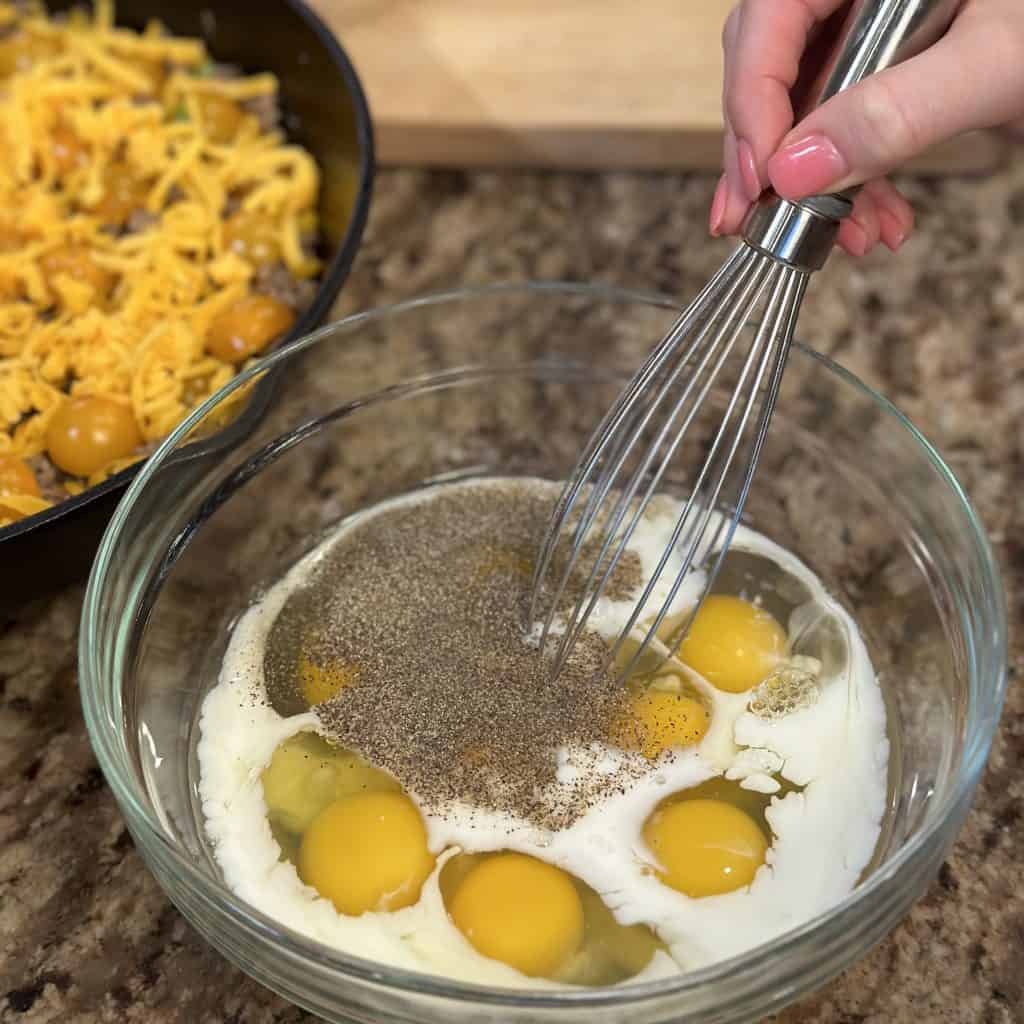 whisking eggs, milk and salt and pepper together