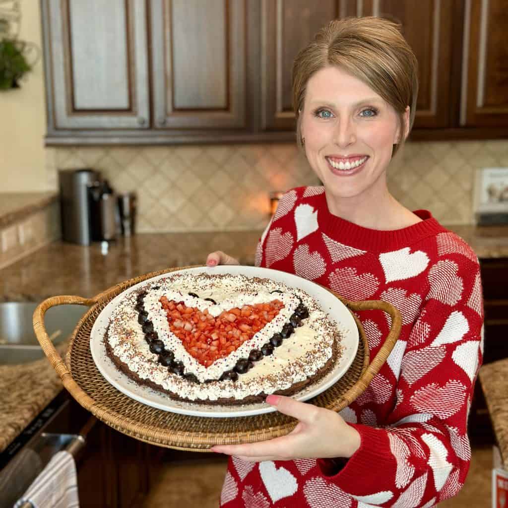 a photo of the author holding a decorated brownie pizza