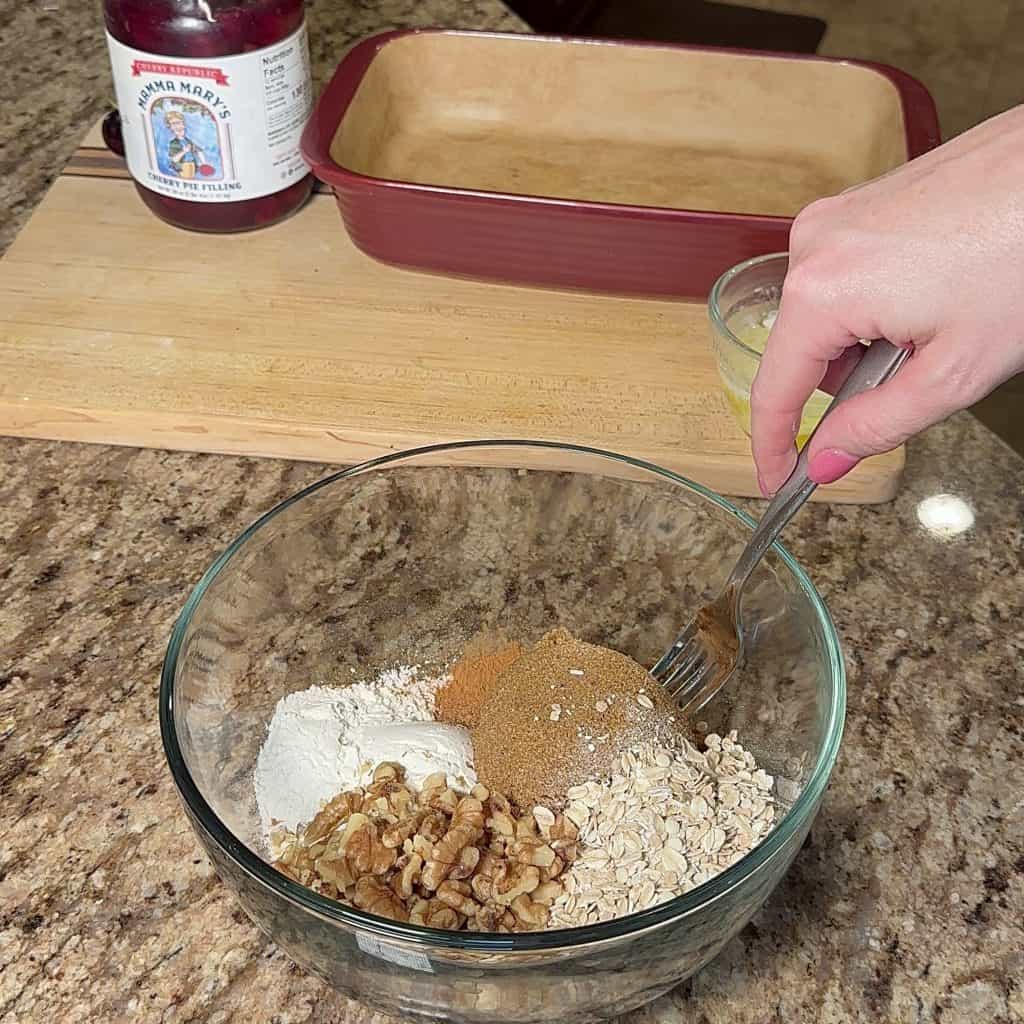 Mixing together streusel ingredients in a glass bowl
