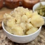 This is a picture of a bowl of boiled potatoes with black pepper on top.