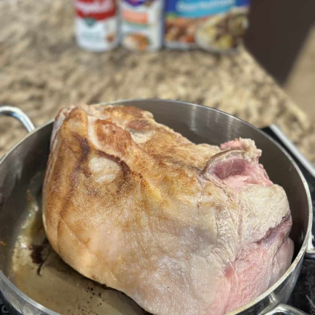 searing the pork roast in a deep pan