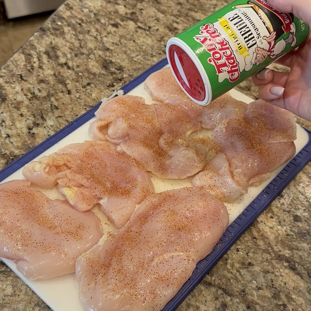 raw chicken being seasoned