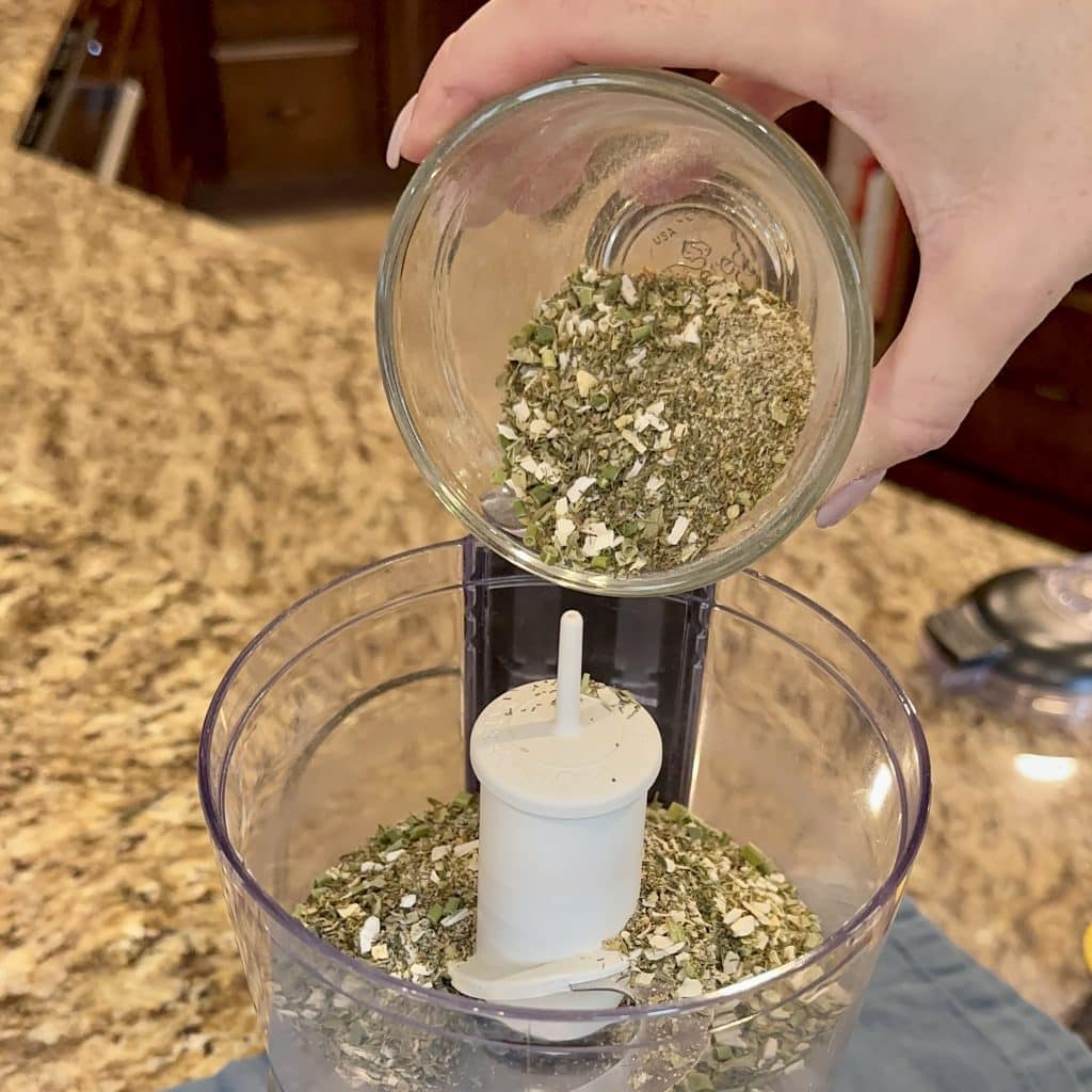 Pouring mixed ranch spices into a food processor