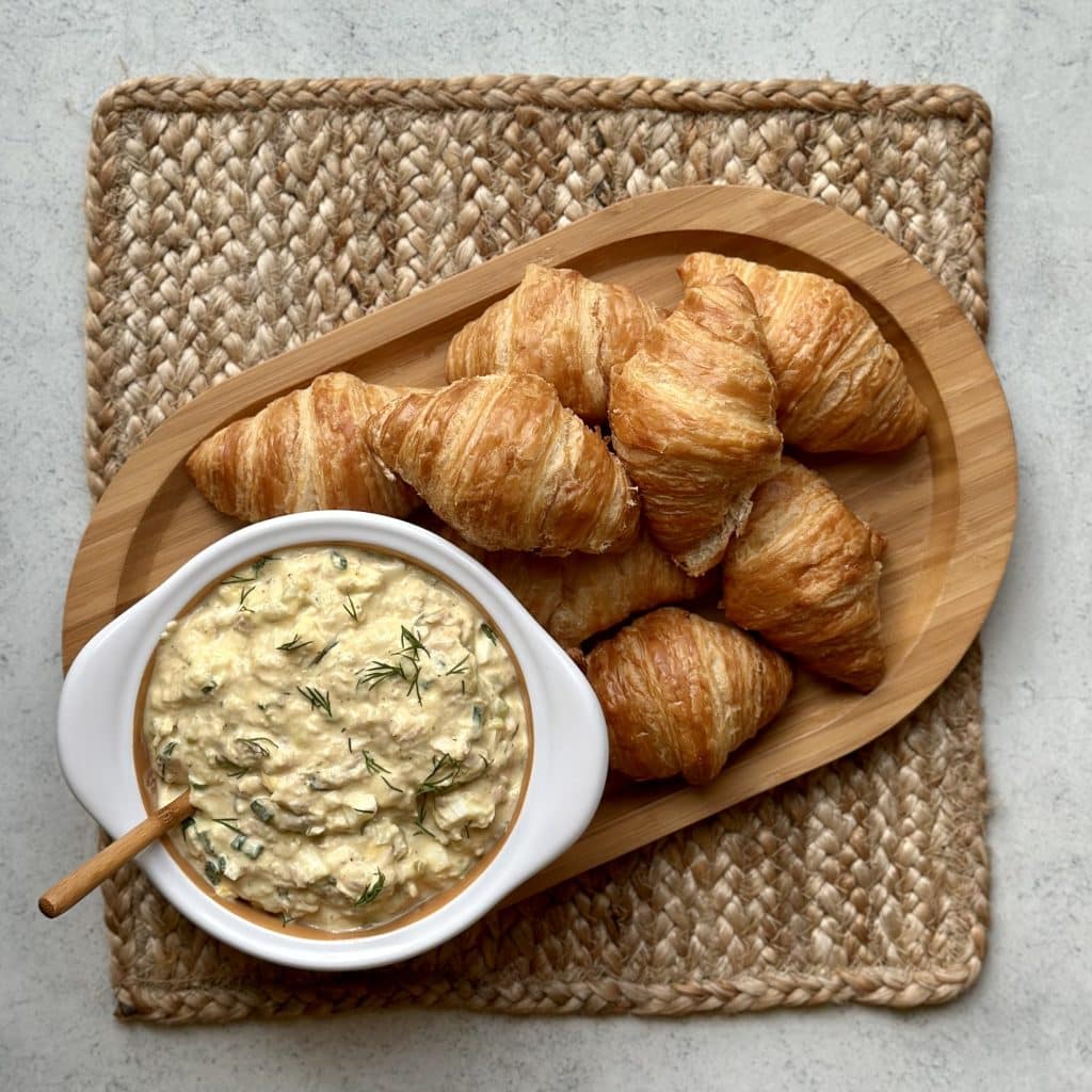 Best Ever Tuna Egg Salad in a bowl ready to be served, with croissants on the side