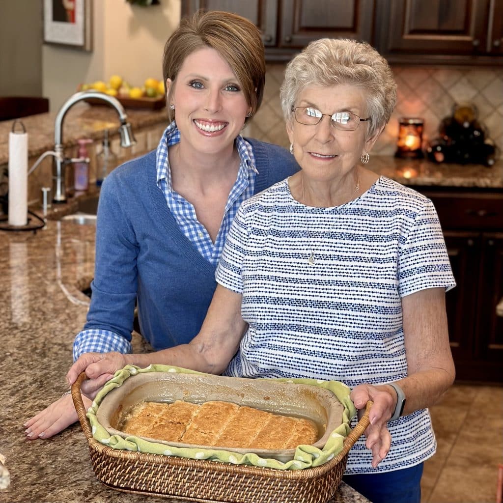 Laura and Mamaw holding a dish of fresh baked rolls