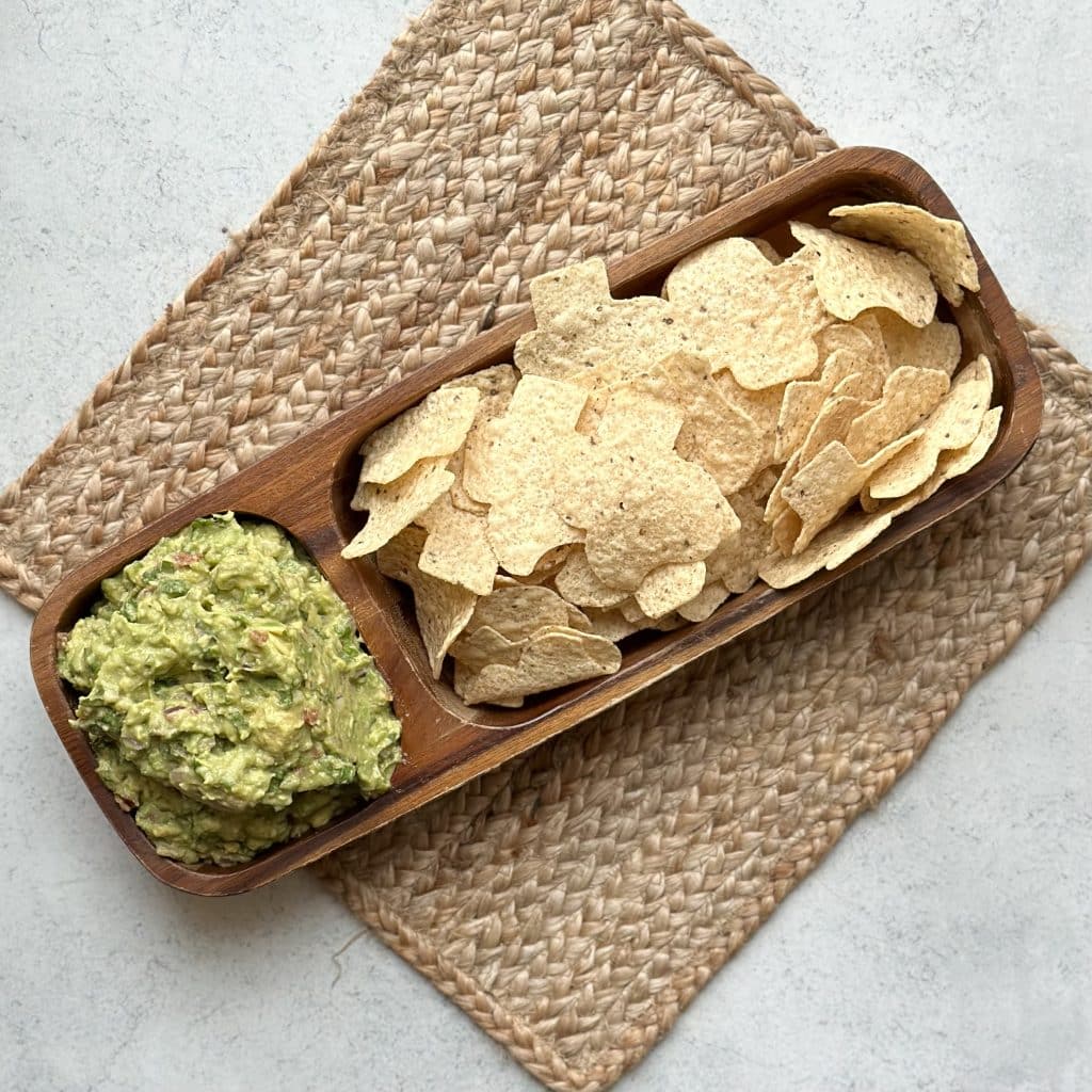 a tray of guacamole and tortilla chips