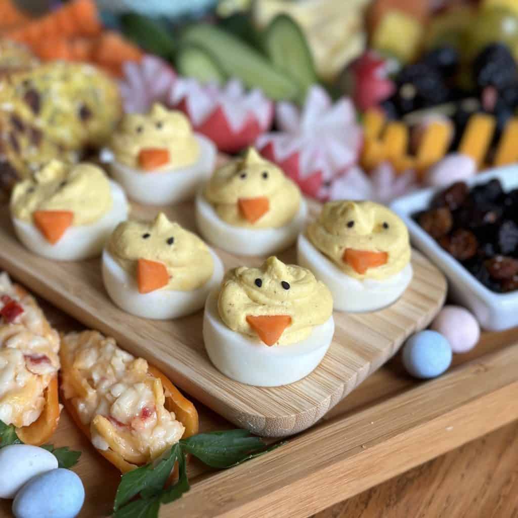 close up view of devilled eggs made to look like spring chicks on charcuterie board