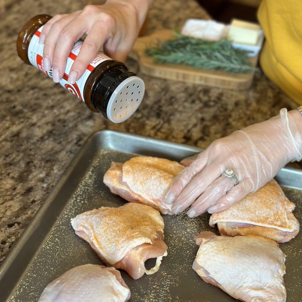 Sprinkling seasoned salt on the chicken thighs