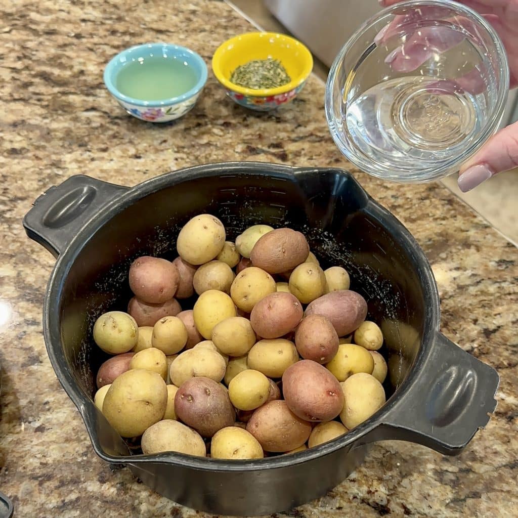 Pouring water over potatoes in a microwave-safe dish