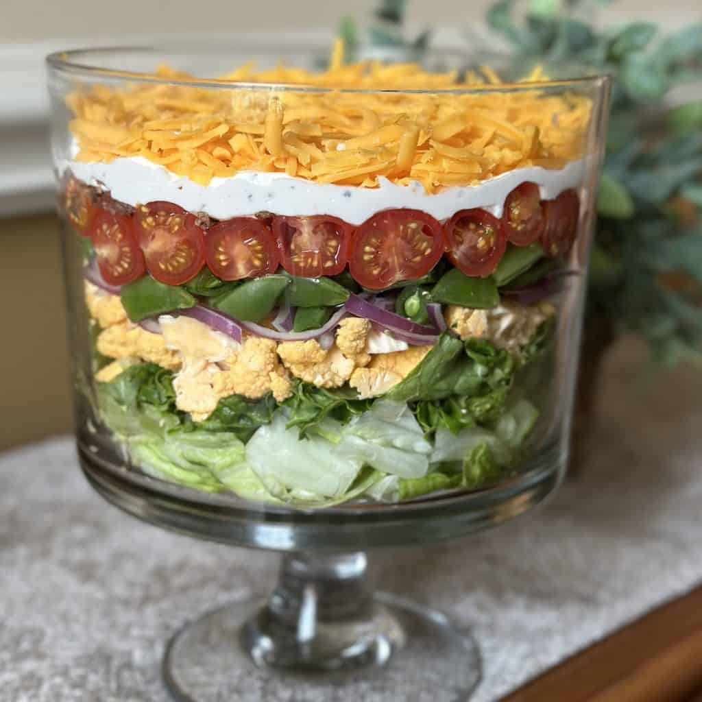 A finished layered salad in a trifle bowl