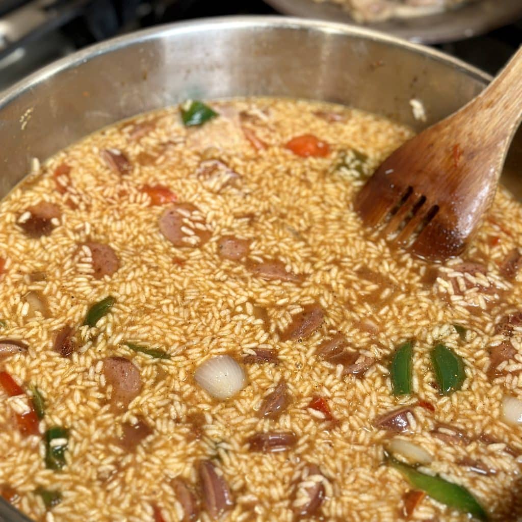 Simmering the pasta, rice, vegetables and sausage