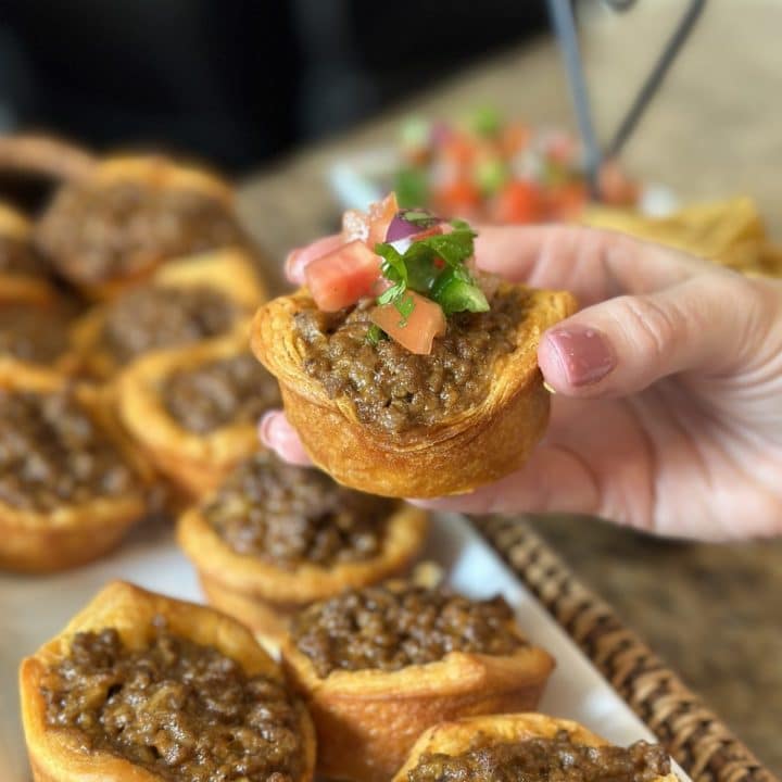 A biscuit crust cup filled with cheesy taco meat and topped with pico de gallo.