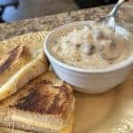 A bowl of cream of mushroom soup with a grilled cheese