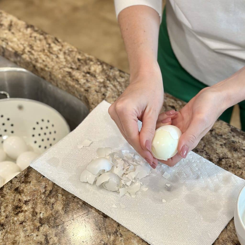 Peeling a boiled egg onto the counter in some paper towel