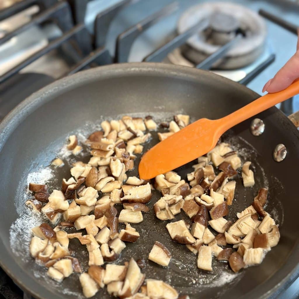 Mushroom pieces being browned in a skillet