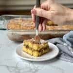 A slice of honey bun cake with a fork going into the cake for a bite.