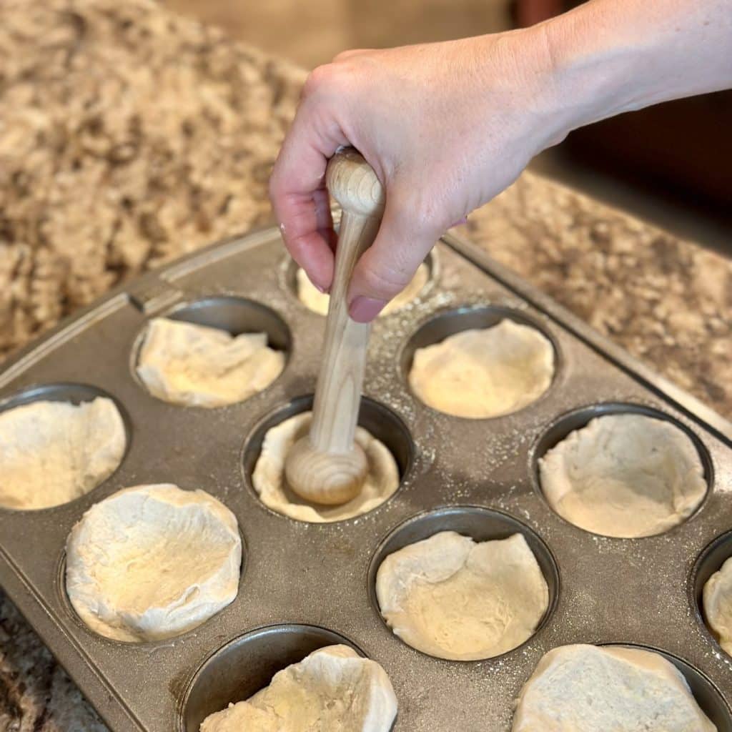 Biscuit dough pressed into a muffin pan  as a crust base