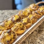 A tray of baked biscuit cups filled with cheesy barbecue pork.