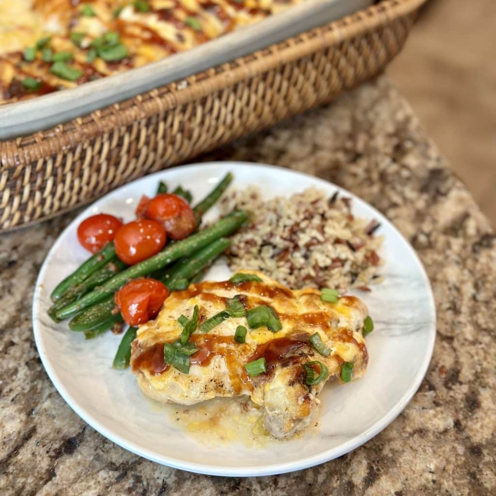 Dinner of green beans and tomatoes  grain blend and chicken topped with barbecue sauce, cheese and green onions