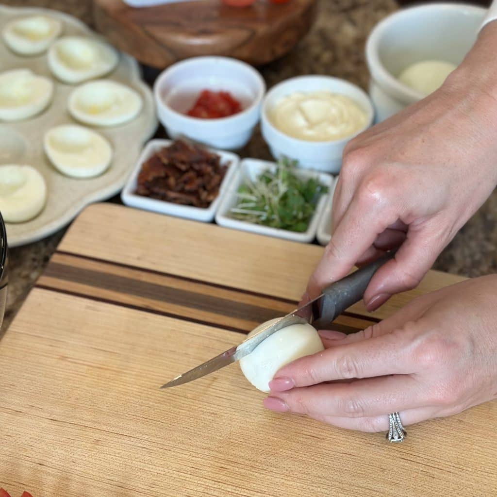Cutting a peeled boiled egg on a cutting board