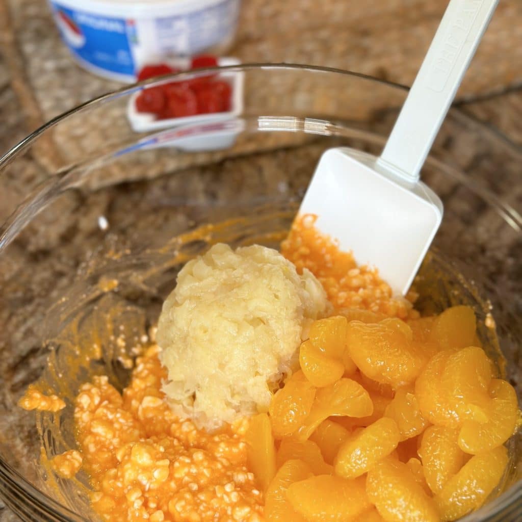 Mandarin oranges, crushed pineapple, being blended into cottage cheese, and orange Jell-O mix.