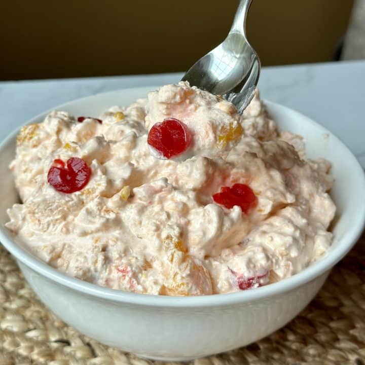 A bowl of orange jello salad.