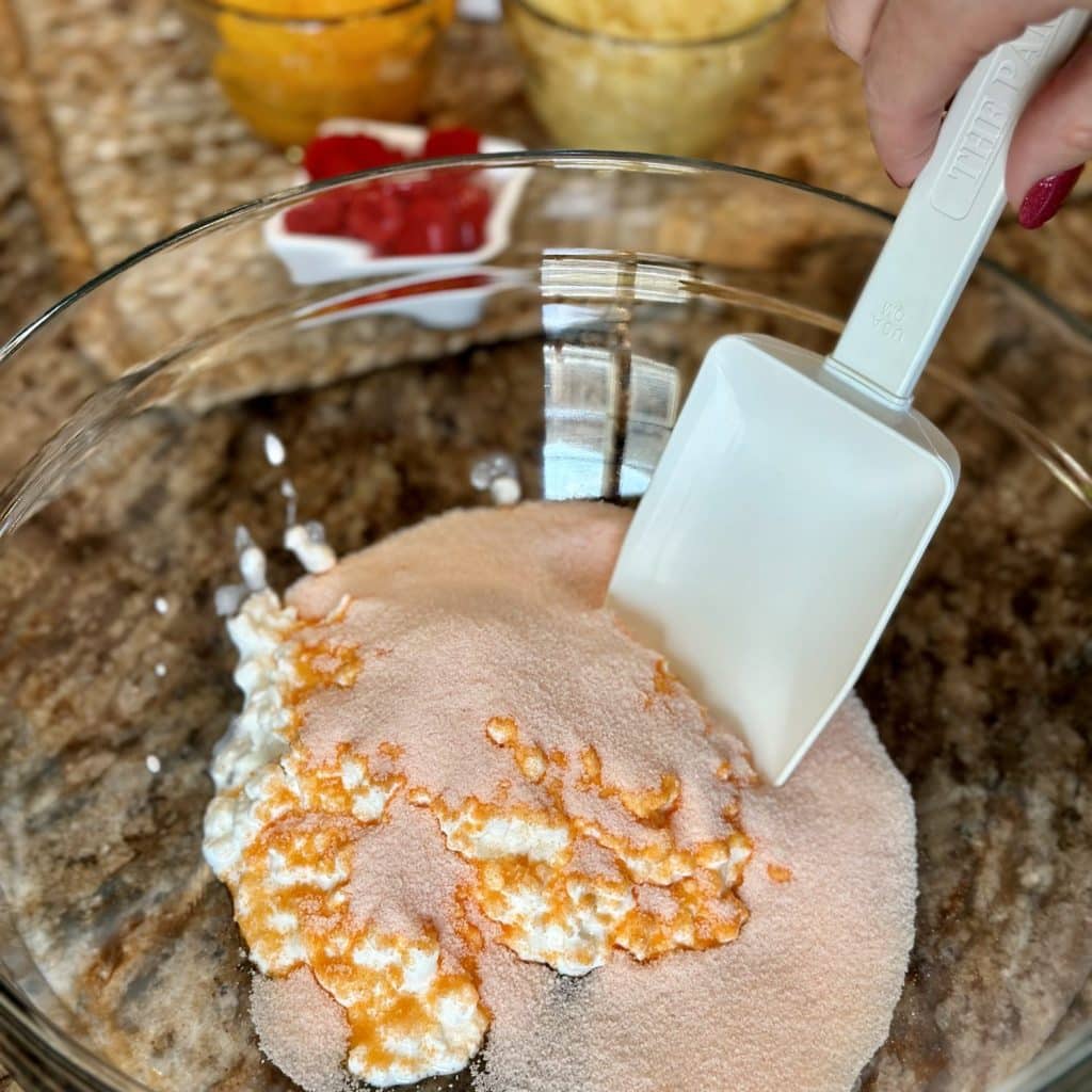 Cottage cheese blended with orange Jell-O mix in a bowl