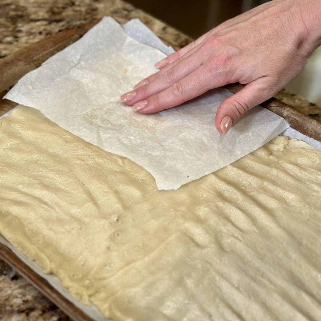 Cookie dough being pressed into a rectangle shape