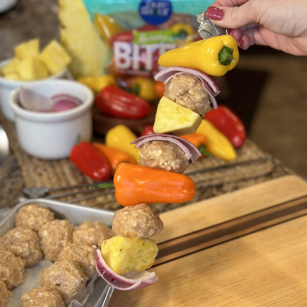 A tropical meatball skewer with meatballs, peppers, onions, and fresh pineapple