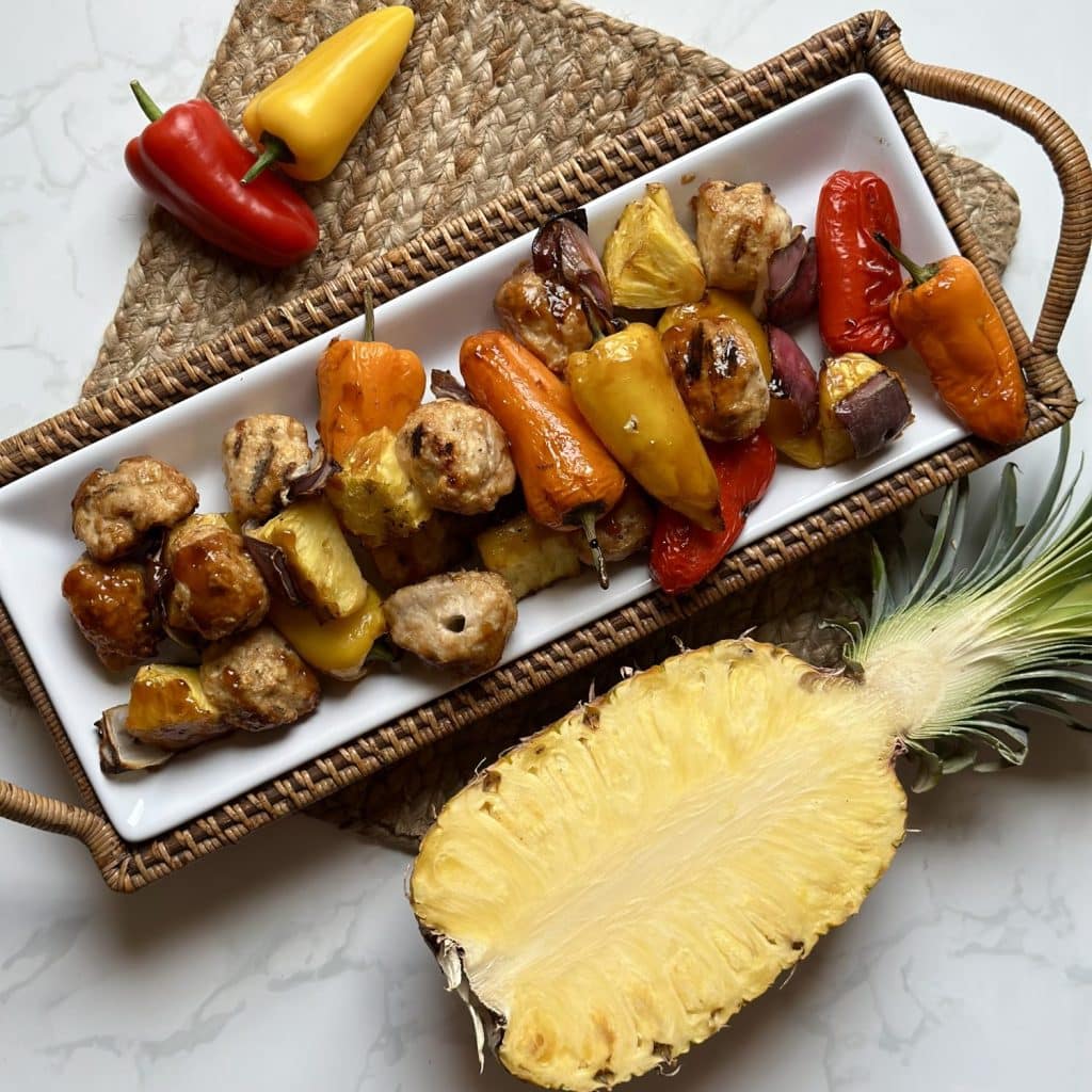 A platter of grilled skewers with meatballs, peppers, pineapple, onions and glaze 