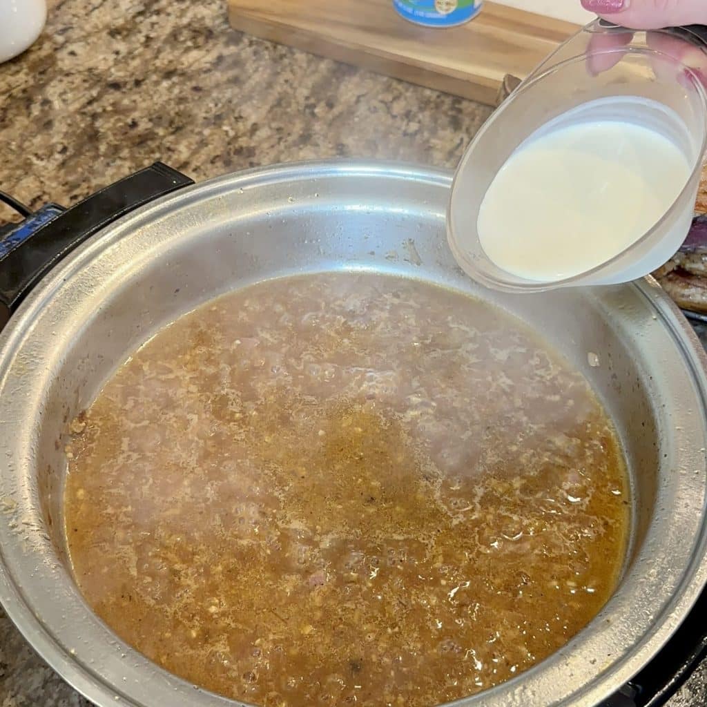 Pouring heavy cream in a skillet of broth.