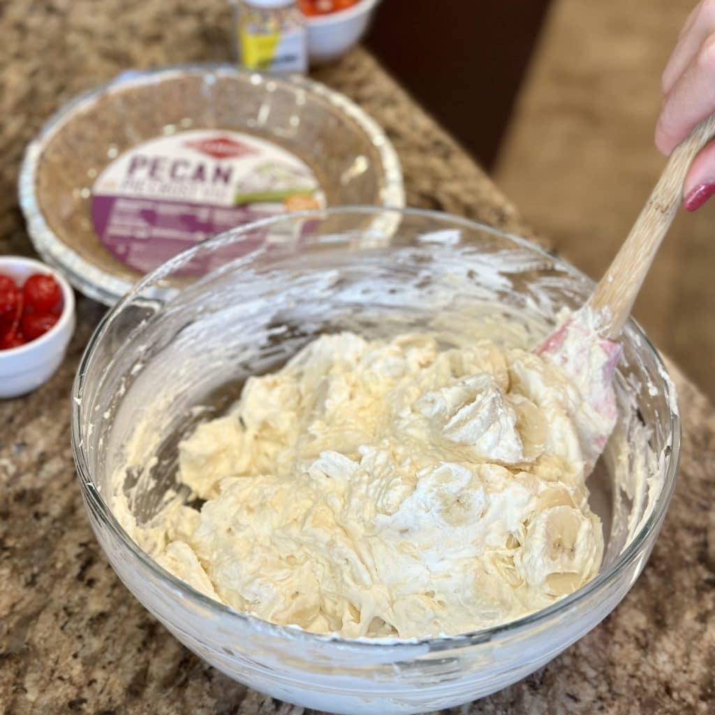 Filling being folded with a spatula for a banana split pie.