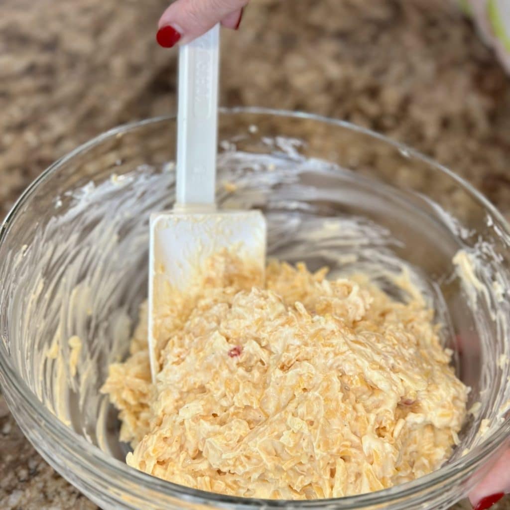 Pimento cheese being mixed in a bowl.