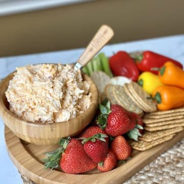 Pimento cheese in a bowl with fruits, veggies and crackers.