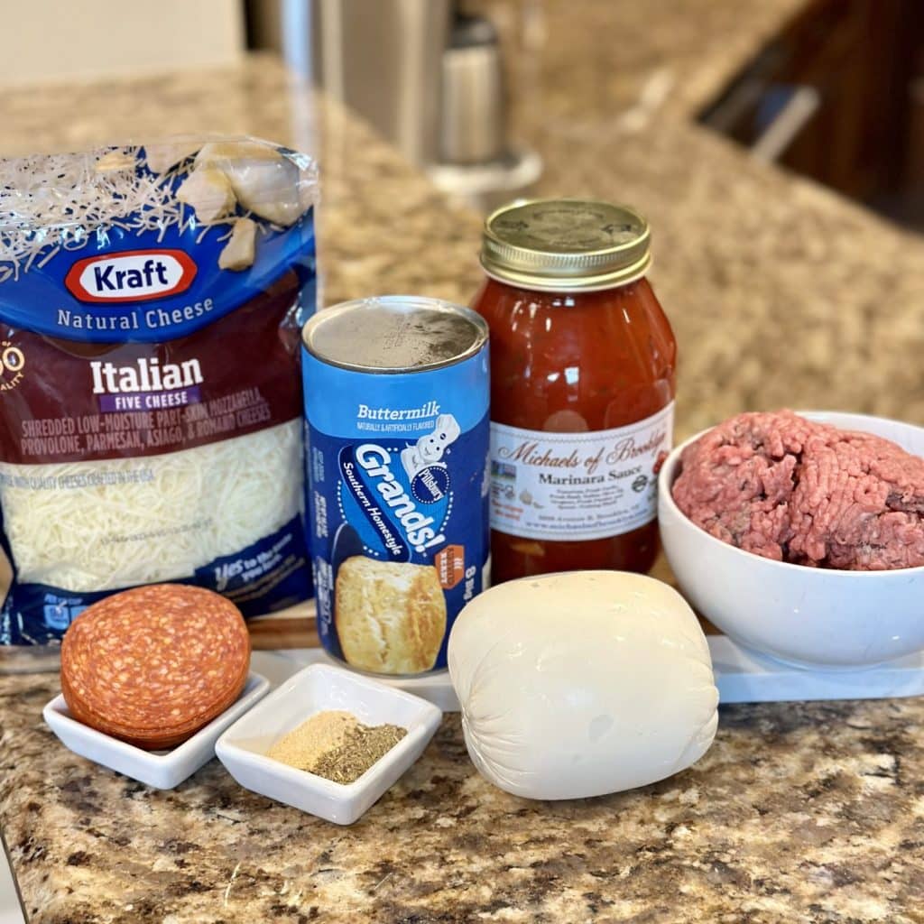 Ingredients to make pizza cups: cheese, Ground beef, marinara sauce, biscuit dough and seasonings.