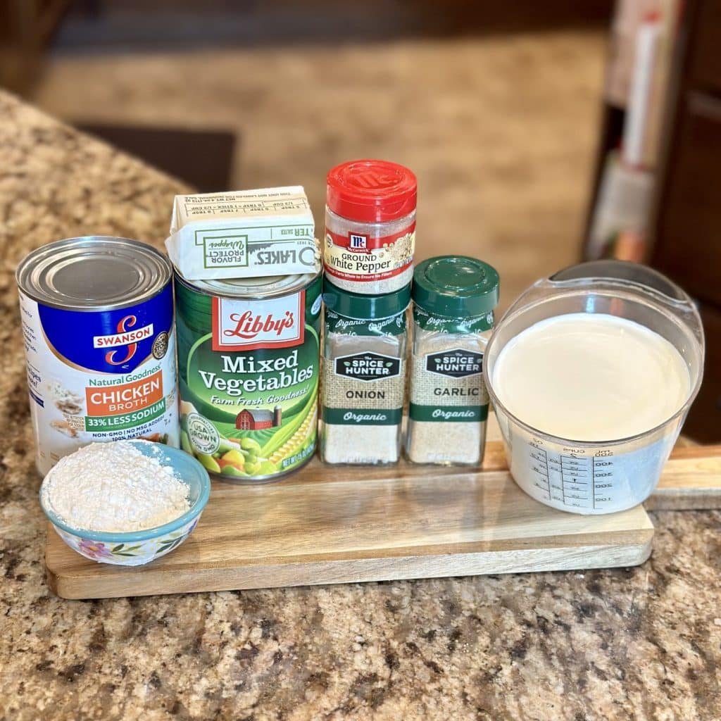 Ingredients to make soup: half and half, flour, seasonings, broth, mixed vegetables and butter.