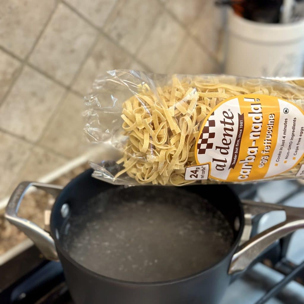Pouring pasta in boiling salted water.