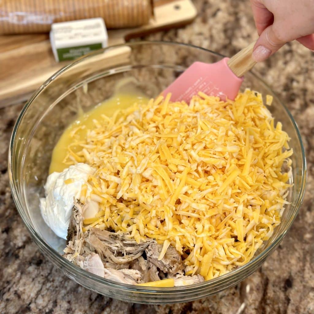 Mixing a chicken bake mixture of ingredients in a large bowl.