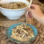 A fork gathering a bite of beef stroganoff to eat