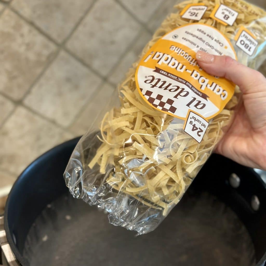 Pasta about to be poured in a pot of salted water.