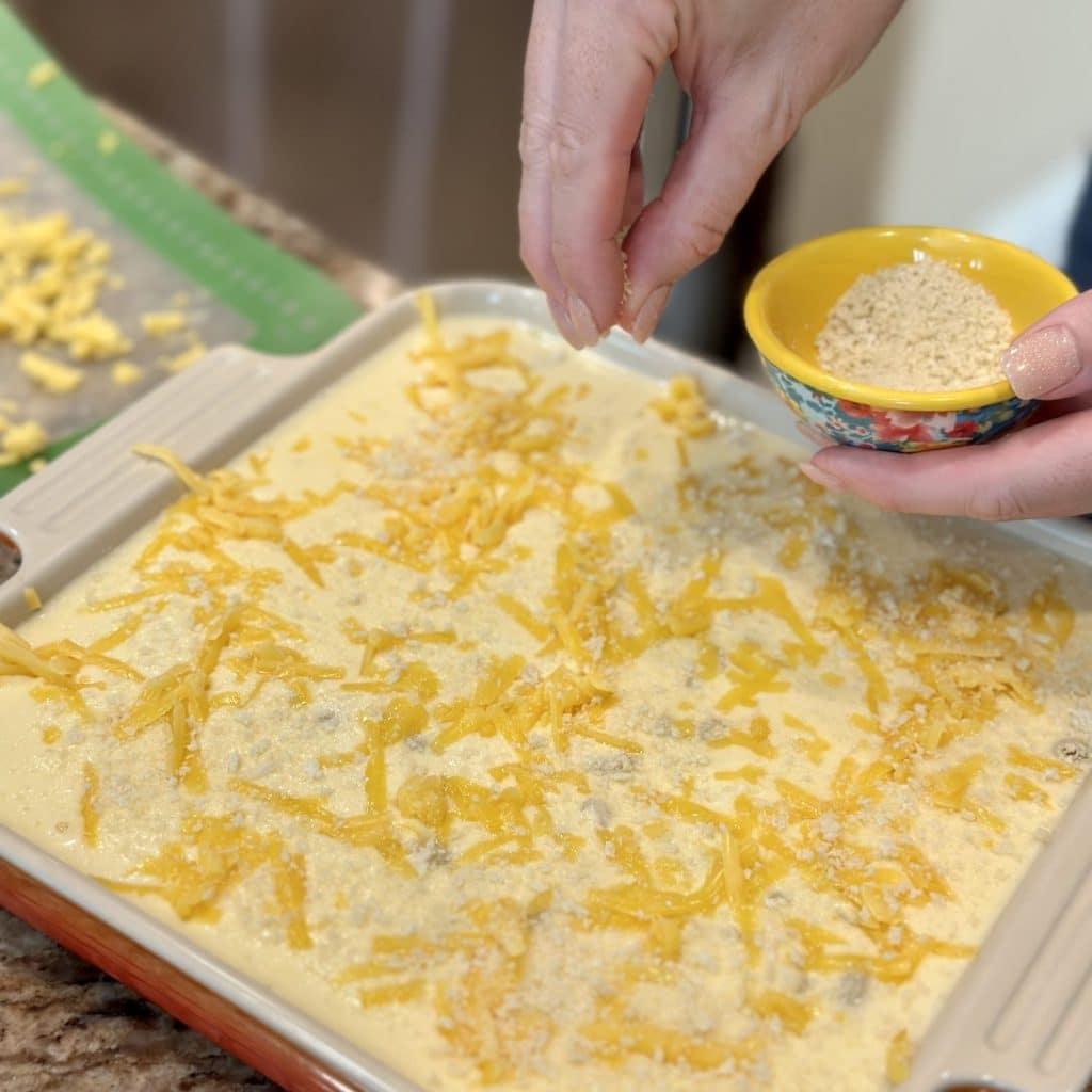 Sprinkling panko on top of macaroni and cheese.